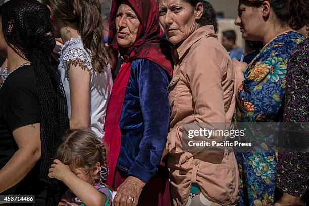 Kurdish women queue for lunch outside the Saint Joseph Church as 650 Kurdish Christian families have taken shelter inside Saint Joseph Church, after...