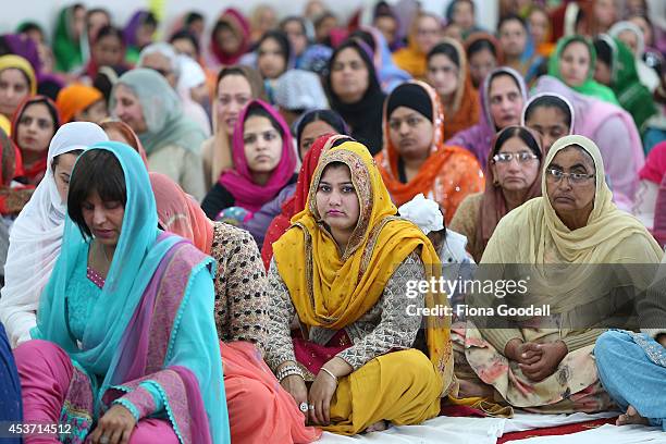 Spectators listen to New Zealand Prime Minister John Key as he speaks during a visit to Sikh Temple 'Gurudwara Sri Dasmesh Darbar' in Papatoetoe on...