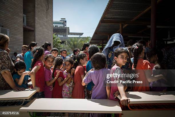 Kurdish people queue for lunch outside Saint Joseph Church. 650 Christian families have taken shelter inside Saint Joseph Church, after an...