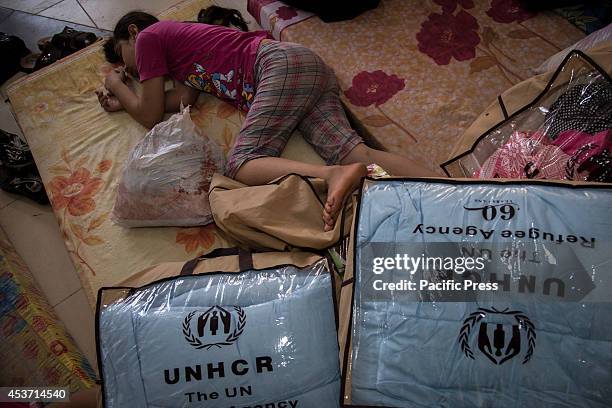 Young Kurdish child sleeps on the mattress she has been allocated next to UNHCR donated blankets. 650 Christian families have taken shelter inside...
