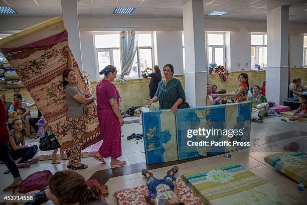 Young Kurdish mothers setting up mattresses. 650 Christian families have taken shelter inside Saint Joseph Church, after an unprecedented ISIS...