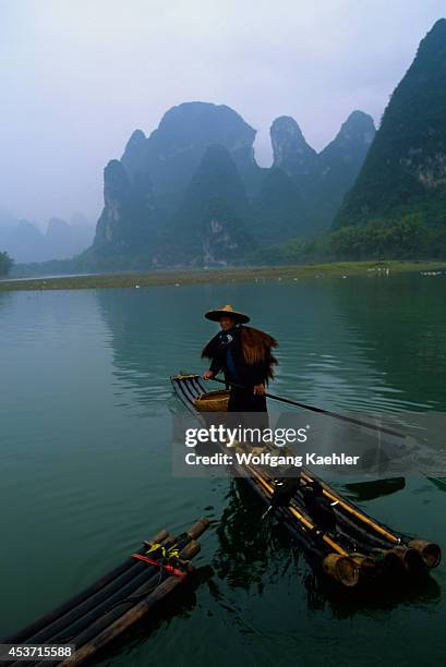 China, Guangxi Province, Near Guilin, Xing Ping, Li River, Rain, Fisherman On Bamboo Raft, Cormorants.