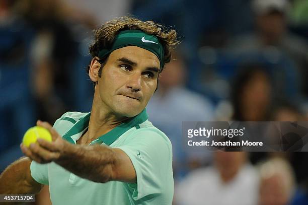 Roger Federer of Switzerland serves against Milos Raonic of Canada during a match on day 8 of the Western & Southern Open at the Linder Family Tennis...
