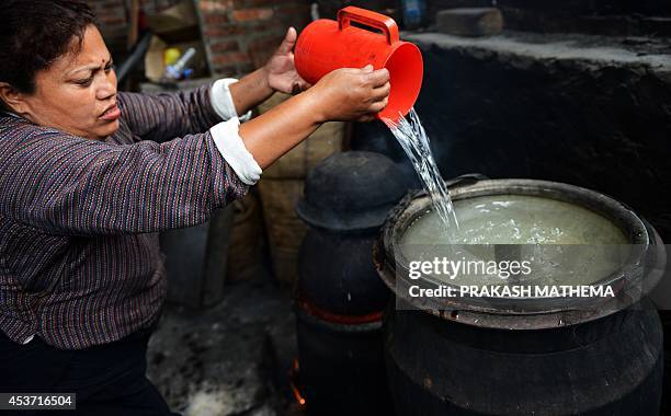 To go with NEPAL-CULTURE-FOOD-DRINK by Paavan Mathema In this photograph taken on June 6 a Nepalese resident heats water as she prepares to make...