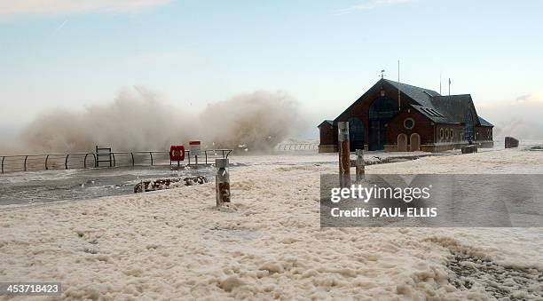 The tide turns to froth by the Lifeboat Station on the promenade as waves batter the sea wall in Blackpool, north west England, on December 5, 2013...