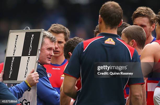 Brendan McCartney the coach of the Bulldogs talks to his players during the round 21 AFL match between the North Melbourne Kangaroos and the Western...