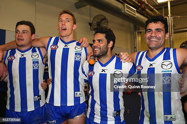 Nathan Grima, Drew Petrie, Daniel Wells and Lindsay Thomas of the Kangaroos sing the song in the rooms after winning the round 21 AFL match between...