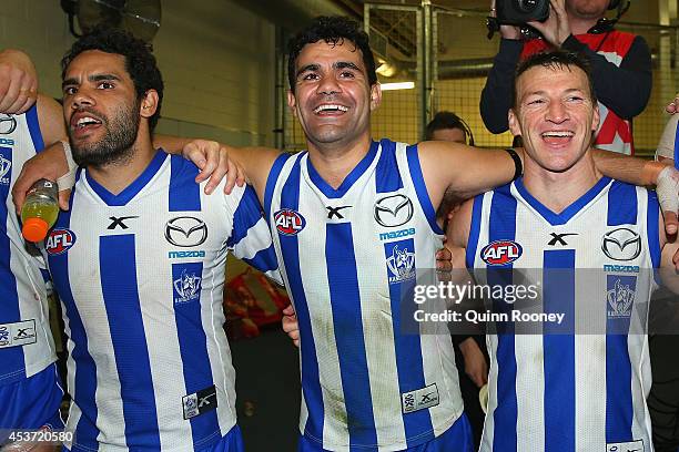 Daniel Wells, Lindsay Thomas and Brent Harvey of the Kangaroos sing the song in the rooms after winning the round 21 AFL match between the North...