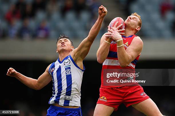 Ben Jacobs of the Kangaroos attempts to spoil a mark by Adam Cooney of the Bulldogs during the round 21 AFL match between the North Melbourne...