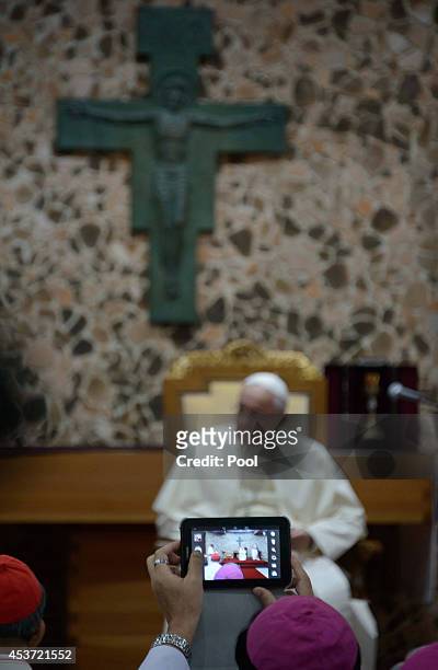 Bishop uses a tablet to take a photo as Pope Francis attends a meeting with Asian bishops at the Haemi Martyrs Shrine on August 17, 2014 in Haemi,...