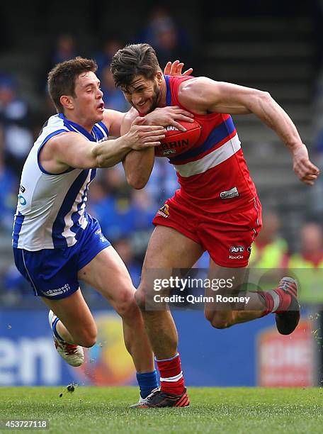 Koby Stevens of the Bulldogs is tackled by Ryan Bastinac of the Kangaroos during the round 21 AFL match between the North Melbourne Kangaroos and the...