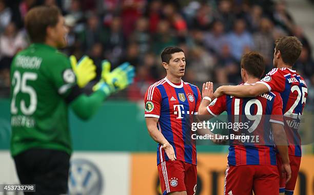 Mario Goetze of Muenchen celebrates with team mates Robert Lewandowski and Thomas Mueller after scoring his teams first goal during the DFB Cup first...