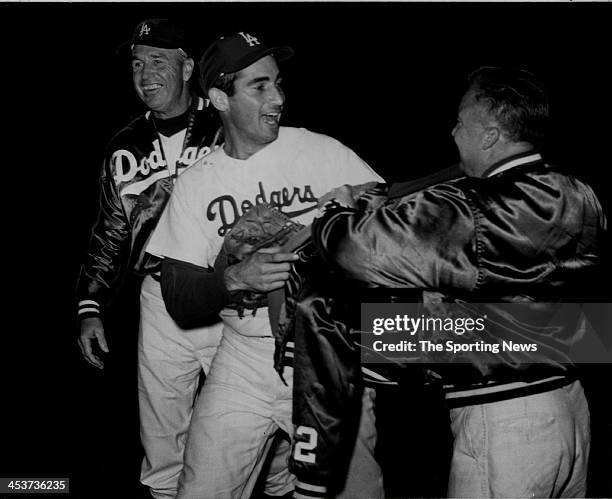 Sandy Koufax of the Los Angeles Dodgers greeted by manager Walter "Smokey" Alston & Trainer Wayne Anderson after Kofaux pitched a no-hitter against...