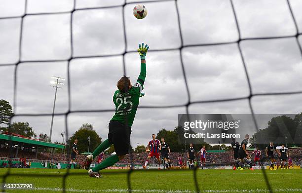 David Alaba of Muenchen scores his teams third goal past goalkeeper Daniel Masuch of Muenster during the DFB Cup first round match between Preussen...