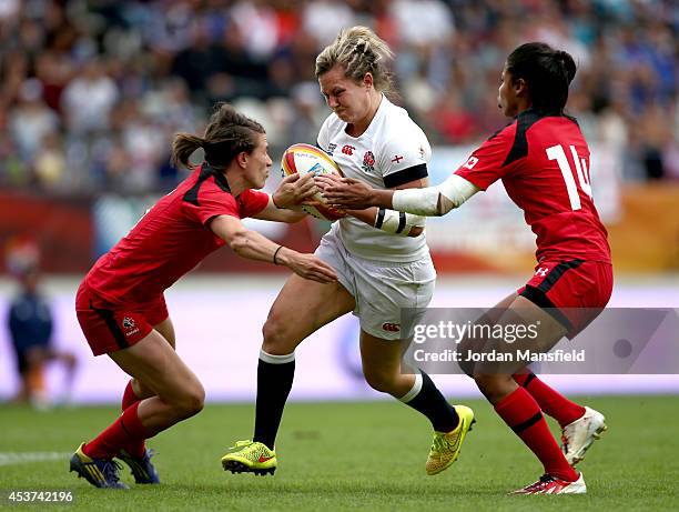 Marlie Packer of England is tackled by Magali Harvey and Julianne Zussman of Canada during the IRB Women's Rugby World Cup 2014 Final between England...