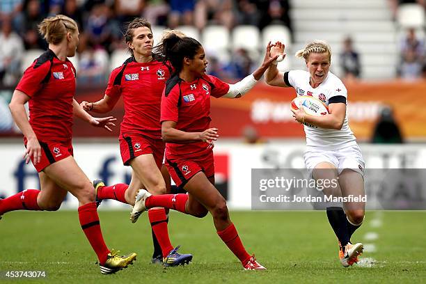 Danielle Waterman of England avoids a challenge by Magali Harvey of Canada during the IRB Women's Rugby World Cup 2014 Final between England and...