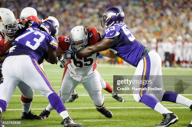 John Estes of the Arizona Cardinals blocks the progress of Sharrif Floyd and Shamar Stephen of the Minnesota Vikings during the game on August 16,...