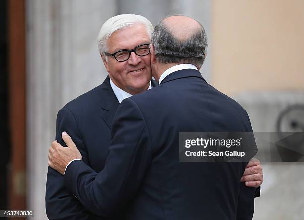 German Foreign Minister Frank-Walter Steinmeier embraces French Foreign Minister Laurent Fabius prior to talks with Russian Foreign Minister Sergey...