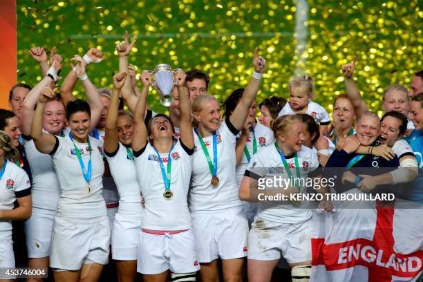 England's players celebrate with the trophy after winning the IRB Women's Rugby World Cup final match between England and Canada at the Jean Bouin...