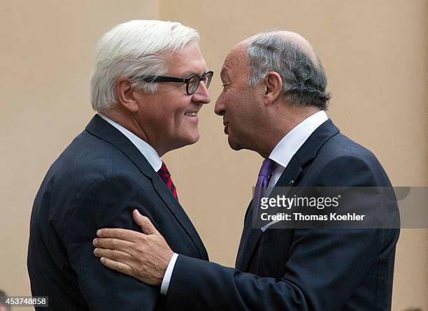 German Foreign Minister Frank-Walter Steinmeier embraces French Foreign Minister Laurent Fabius prior to talks with Russian Foreign Minister Sergey...