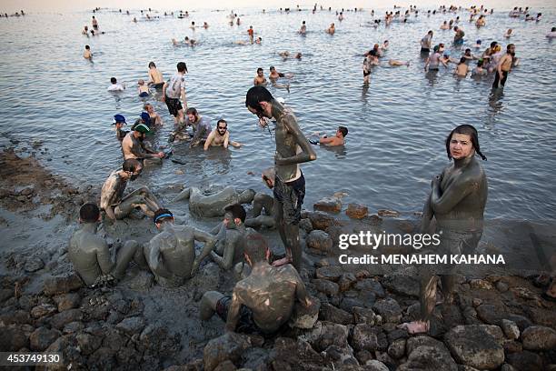 Ultra-Orthodox Jewish men and boys cover their bodies with mineral-rich mud, during their vacation, at a Men's only beach on the shores of the...