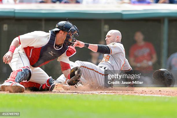Catcher Yan Gomes of the Cleveland Indians tries t make the tag as Steve Pearce of the Baltimore Orioles scores during the sixth inning at...