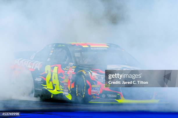 Jeff Gordon, driver of the Axalta Chevrolet, celebrates with a burnout after winning the NASCAR Sprint Cup Series Pure Michigan 400 at Michigan...