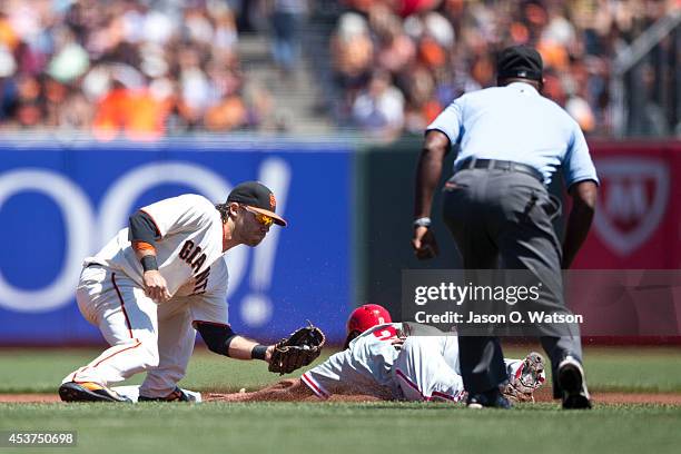 Ben Revere of the Philadelphia Phillies is tagged out attempting to steal second base by Brandon Crawford of the San Francisco Giants in front of...