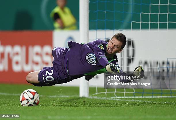 Goalkeeper Max Gruen of Wolfsburg saves the decisive penalty of Milan Ivana of Darmstadt in the shootout during the DFB Cup first round match between...