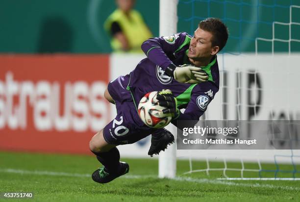 Goalkeeper Max Gruen of Wolfsburg saves the decisive penalty of Milan Ivana of Darmstadt in the shootout during the DFB Cup first round match between...