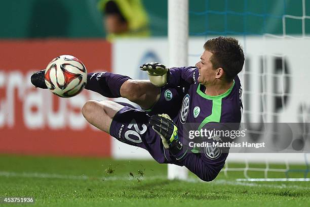 Goalkeeper Max Gruen of Wolfsburg saves a penalty of Maurice Exslager of Darmstadt in the shootout during the DFB Cup first round match between SV...