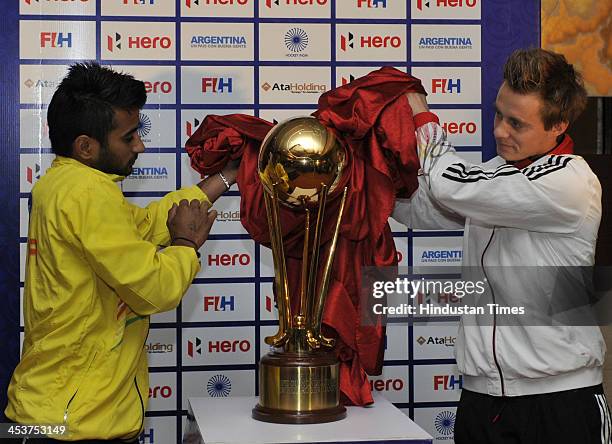 Indian Junior Mens Hockey Team Captain Manpreet Singh with a member of Germany Team Grambusch Mats unveil the Championship Trophy by FIH in a formal...