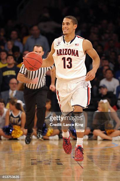 Nick Johnson of the Arizona Wildcats dribbles up court against the Drexel Dragons during their semifinal game of the NIT Season Tip-Off at Madison...
