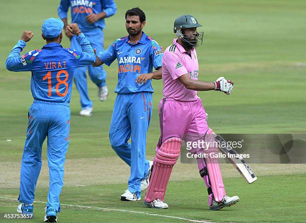 Hashim Amla of South Africa walks off for 65 runs as Virat Kohli and India team-mates celebrate during the 1st Momentum ODI match between South...