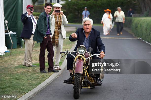 Entertainer Jay Leno rides a 1930 Bohmerland motorcycle during the 2014 Pebble Beach Concours d'Elegance in Pebble Beach, California, U.S., on...