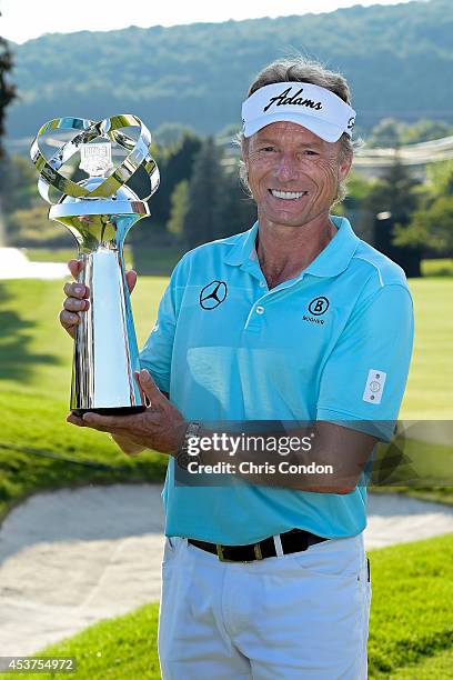 Bernhard Langer of Germany holds the tournament trophy after winning the Champions Tour Dicks Sporting Goods Open at En-Joie Golf Course on August...