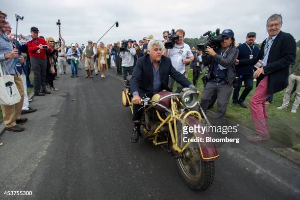 Entertainer Jay Leno rides a 1930 Bohmerland motorcycle during the 2014 Pebble Beach Concours d'Elegance in Pebble Beach, California, U.S., on...