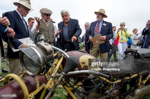 Entertainer Jay Leno, center, talks with John Landstrom, second left, in front of a 1930 Bohmerland motorcycle during the 2014 Pebble Beach Concours...