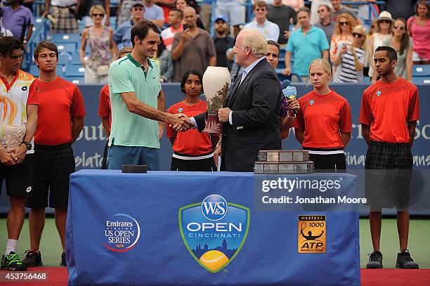 Roger Federer of Switzerland is presented the winner's trophy by John F. Barrett, Chairman, President and Chief Executive Officer of Western &...