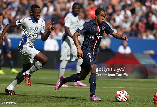 Lucas Moura of PSG in action is watched by El Hadji Ba of Bastia during the French Ligue 1 match between Paris Saint Germain FC and SC Bastia at Parc...