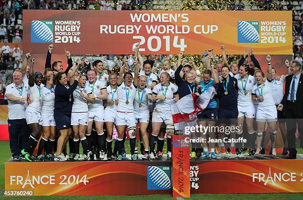 Captain of England Katy McLean lifts the trophy with teammates to celebrate their victory in the IRB Women's Rugby World Cup 2014 Final between...