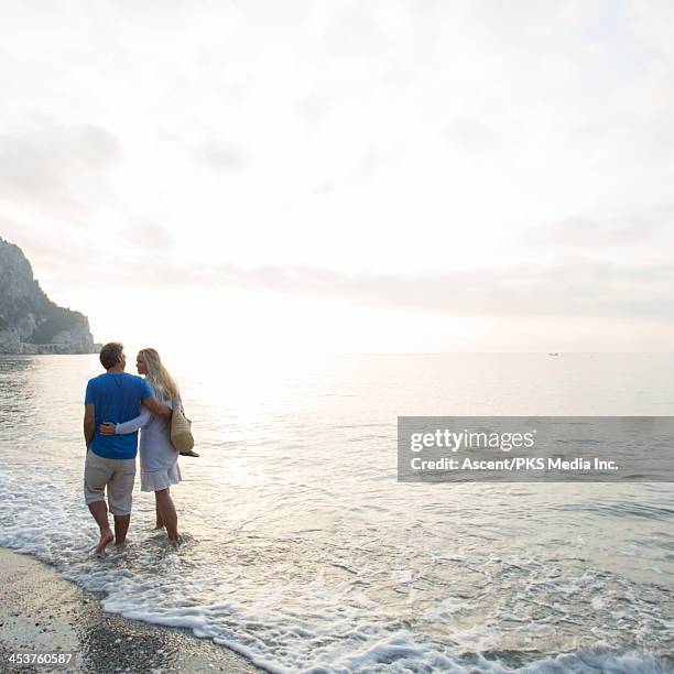 couple walking through sea shallows - ankle deep in water stock pictures, royalty-free photos & images