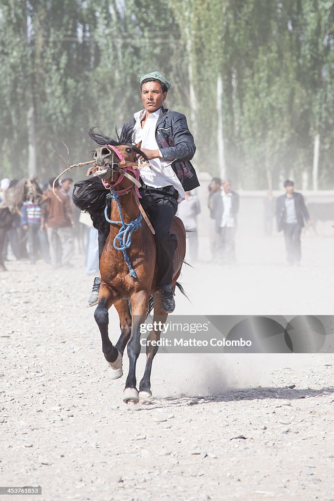 Uyghur man riding a horse at Kashgar market, China