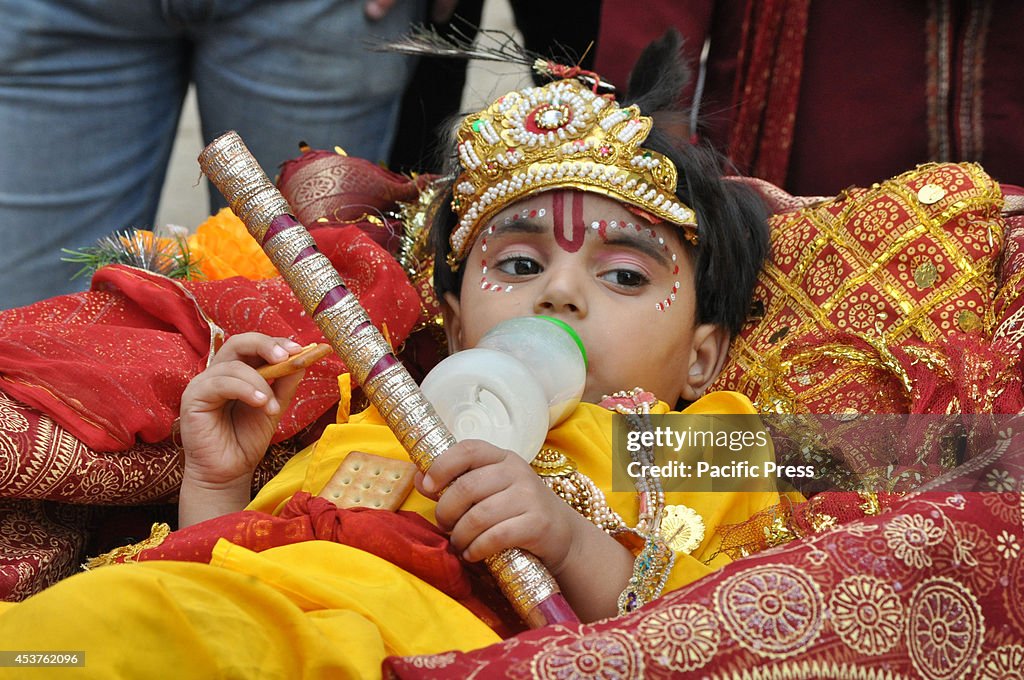 An Indian Child dressed as Hindu God Lord Krishna feeds...
