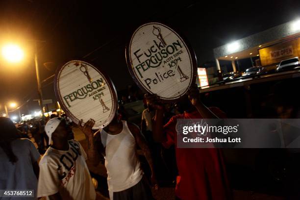 Demonstrators protesting Michael Brown's hold signs August 17, 2014 in Ferguson, Missouri.Despite the Brown family's continued call for peaceful...