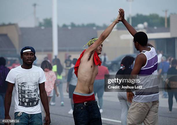 Demonstrators protesting the shooting death of teenager Michael Brown by police high-five each other August 17, 2014 in Ferguson, Missouri. Despite...