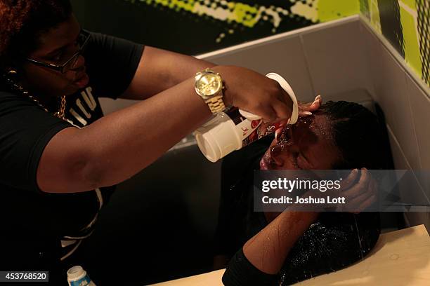 Woman has her face doused with water after being tear gassed by police as she was protesting the shooting death of teenager Michael Brown by police...