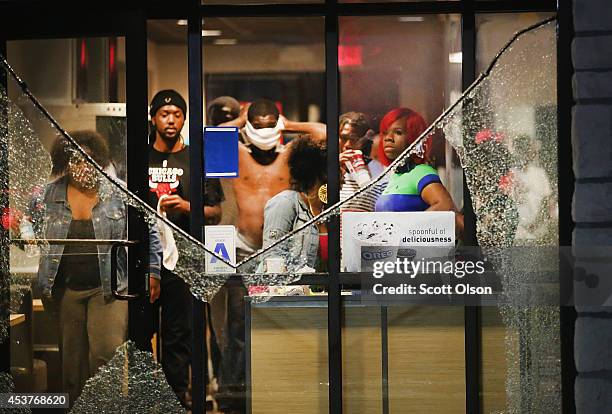 People take cover from tear gas inside a McDonald's restaurant after a demonstration over the killing of teenager Michael Brown by a Ferguson police...