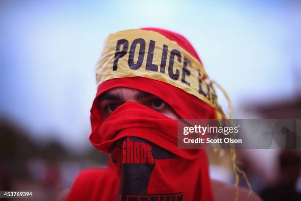 Demonstrator wears a makeshift headscarf with police tape around it as he takes part in a protest at the killing of teenager Michael Brown on August...