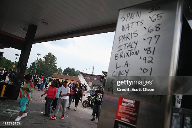 Reference to protests around the world throughout recent history is written on a sign as demonstrators protest the killing of teenager Michael Brown...